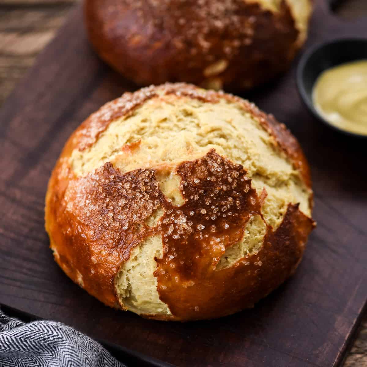 two loaves of pretzel bread on a cutting board