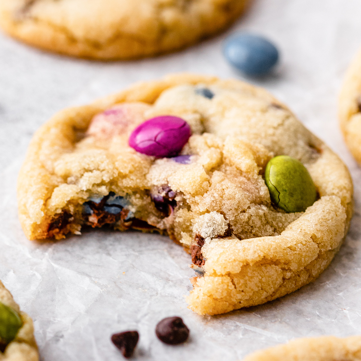 front view of one M & M cookie with a bite taken out of it