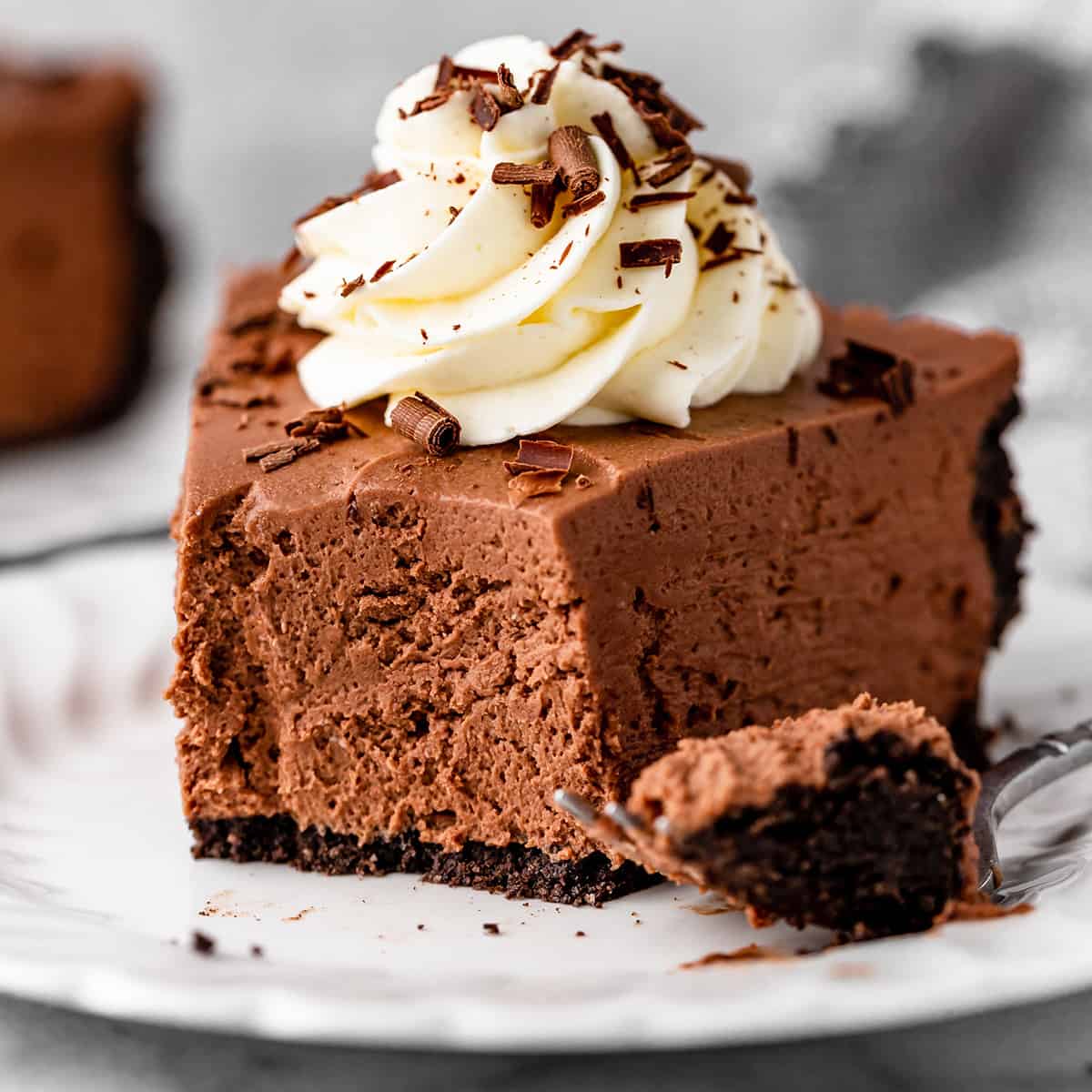 a piece of No Bake Chocolate Cheesecake on a plate with a bite taken out of it