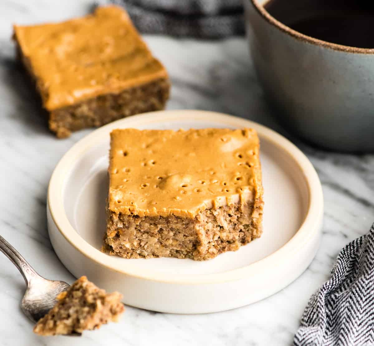 a peanut butter breakfast bar on a plate with a bite taken out of it. 