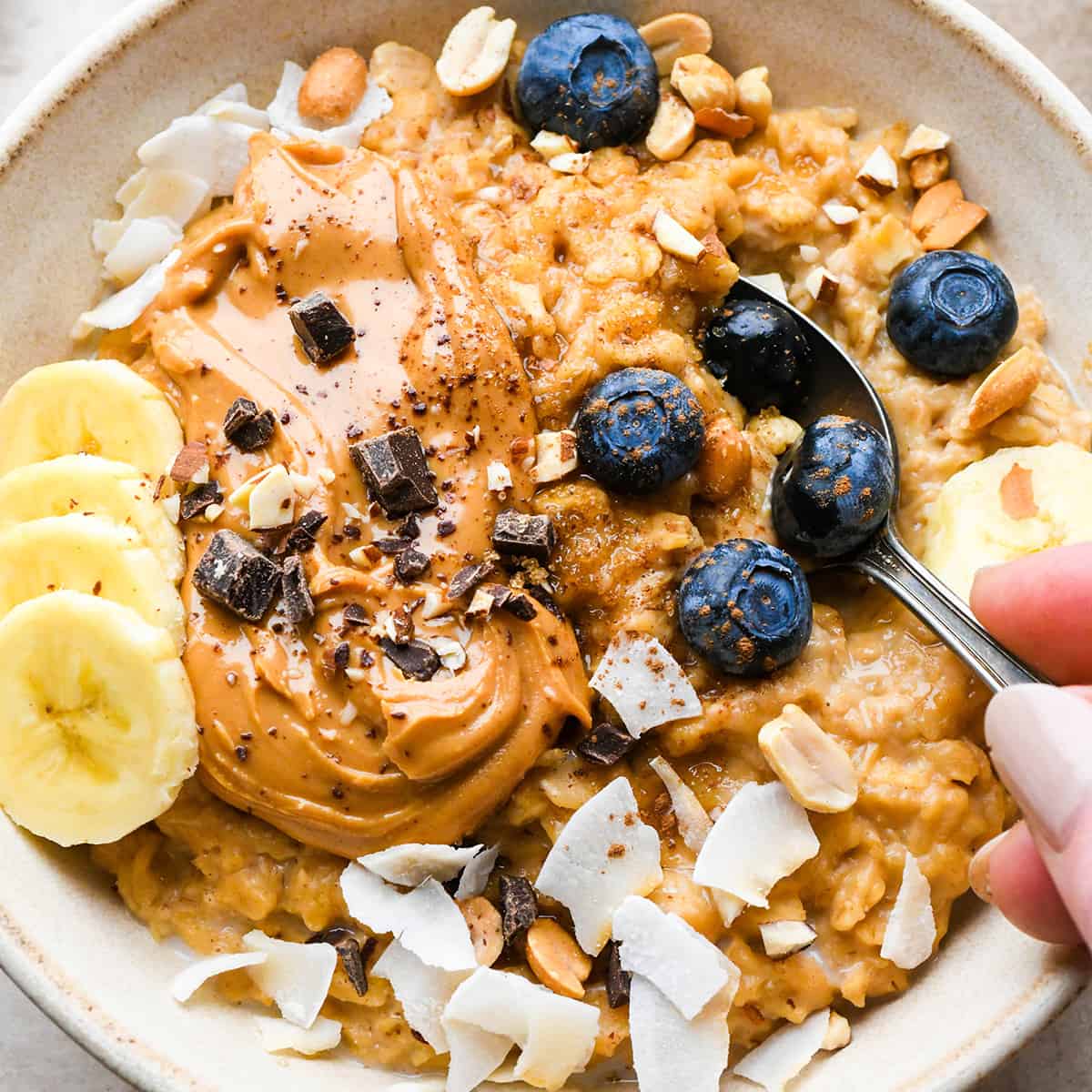 a spoon taking a scoop of Peanut Butter Oatmeal out of a bowl