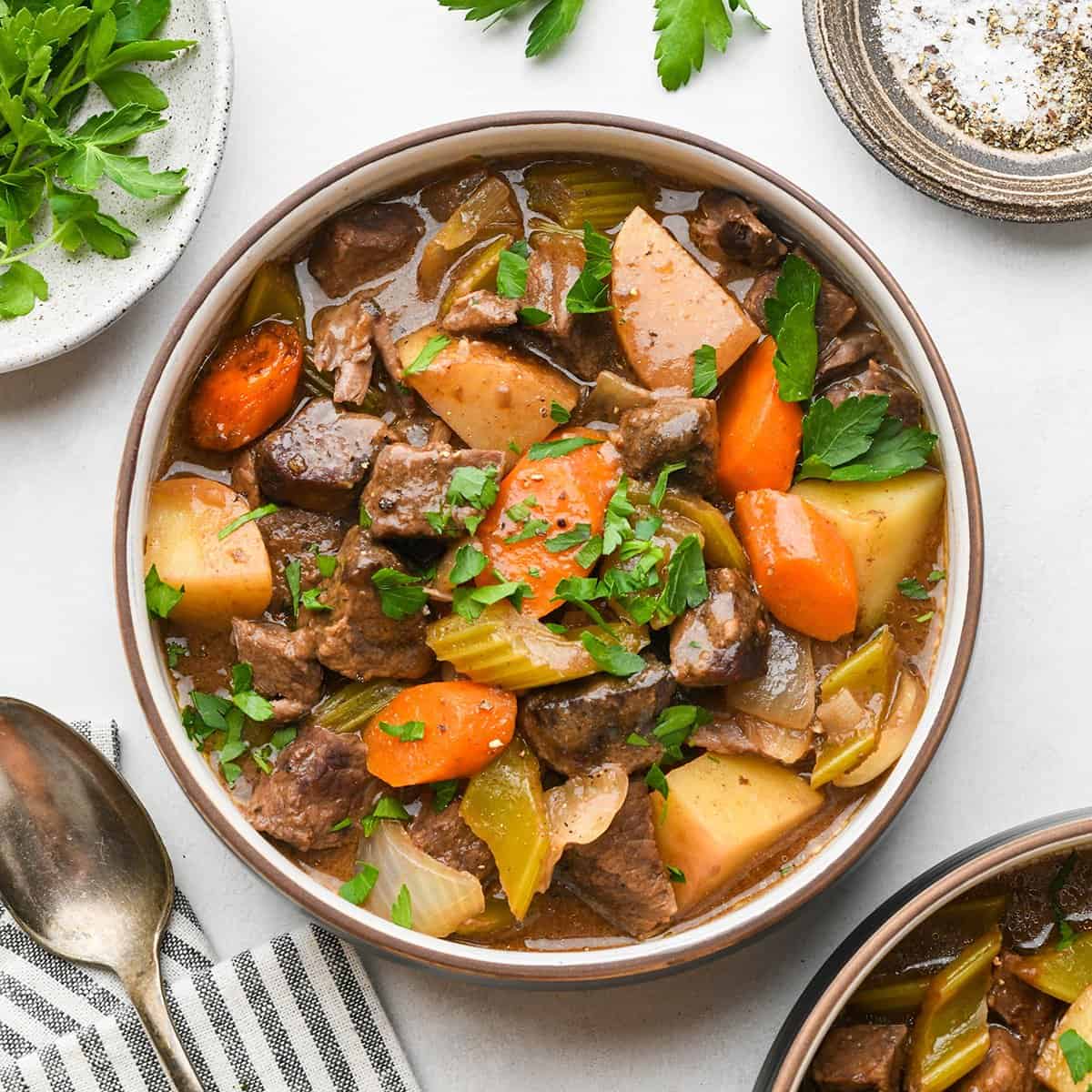 a bowl of Slow Cooker Beef Stew garnished with fresh parsley.