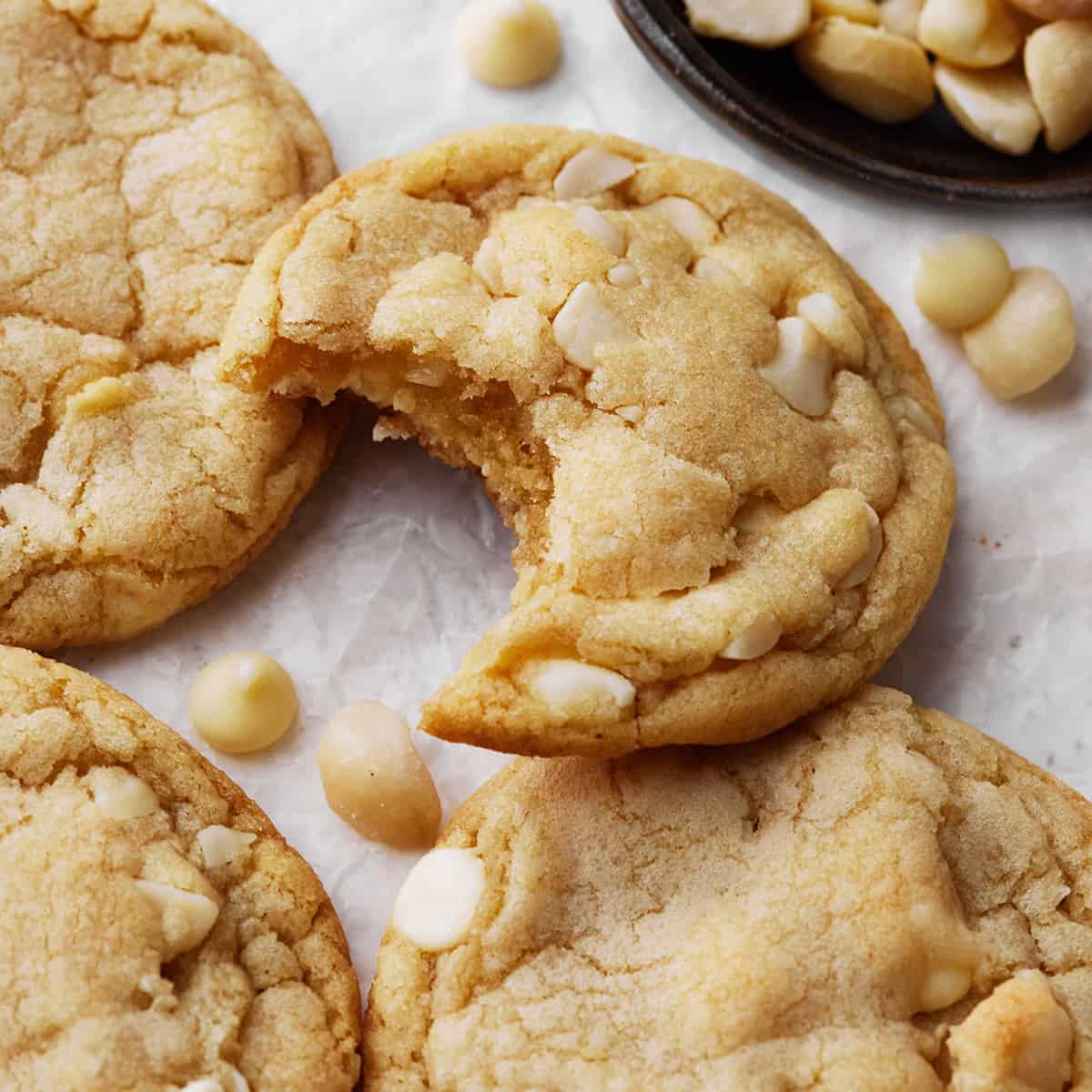 4 White Chocolate Macadamia Nut Cookies, one has a bite taken out of it